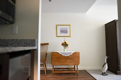 The Inn at Fairview, nursing home in Hudson, NH — Brightly decorated living space with a wooden table and flowers