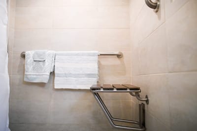 The Inn at Fairview, nursing home in Hudson, NH — Accessible bathroom shower area with towels and stool