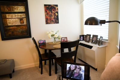 The Inn at Fairview, nursing home in Hudson, NH — Cozy living space with a dining table and photos