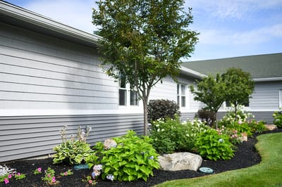 Lush garden adjacent to a gray facility building