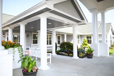 The Inn at Fairview, nursing home in Hudson, NH — Covered entrance with planters and seating area