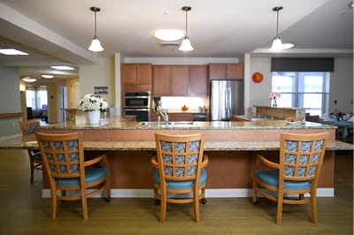The Inn at Fairview, nursing home in Hudson, NH — Kitchen and dining area with seating at a bar counter