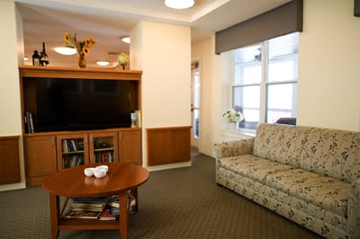 The Inn at Fairview, nursing home in Hudson, NH — Cozy common area with a sofa and entertainment unit