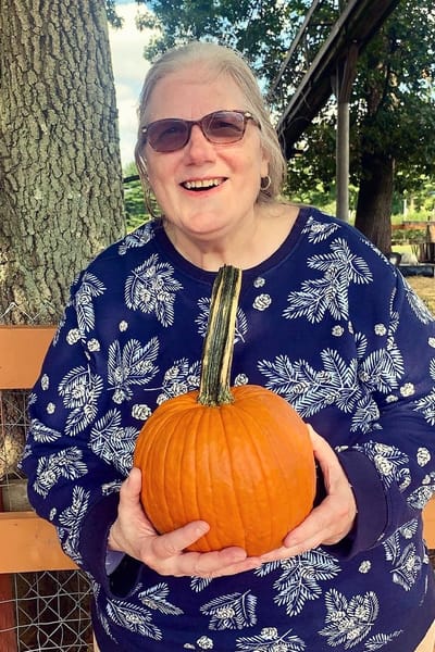 The Inn at Fairview, nursing home in Hudson, NH — Smiling woman holding a large pumpkin outdoors