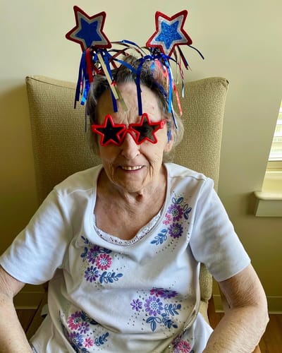 The Inn at Fairview, nursing home in Hudson, NH — Senior resident wearing festive star-themed accessories