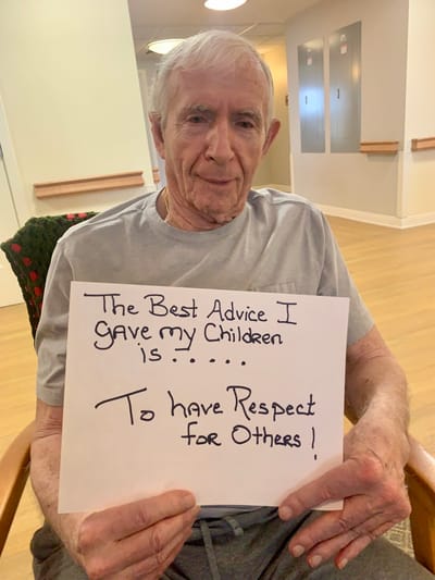 The Inn at Fairview, nursing home in Hudson, NH — Senior man holding a sign with advice for children