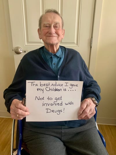 The Inn at Fairview, nursing home in Hudson, NH — Elderly man holding a sign with advice on drugs