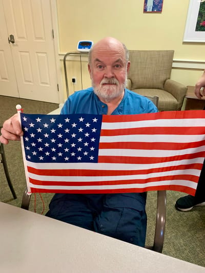 The Inn at Fairview, nursing home in Hudson, NH — Elderly man holding a small American flag