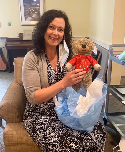The Inn at Fairview, nursing home in Hudson, NH — Woman holding a teddy bear and a gift bag