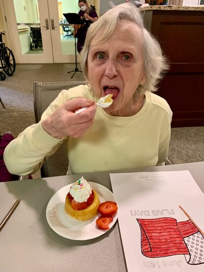 The Inn at Fairview, nursing home in Hudson, NH — Senior woman enjoying cake and strawberries at a table
