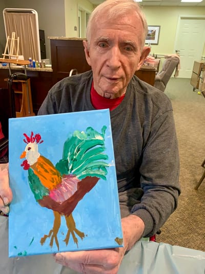 The Inn at Fairview, nursing home in Hudson, NH — Resident holding a colorful painted rooster artwork