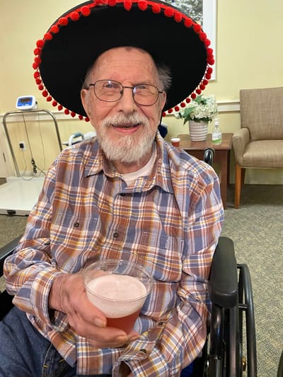 The Inn at Fairview, nursing home in Hudson, NH — Senior man wearing sombrero and holding a drink