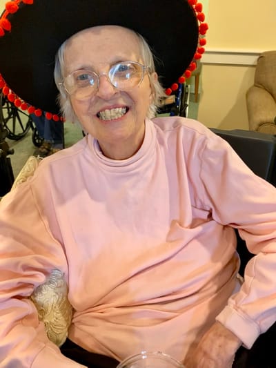 The Inn at Fairview, nursing home in Hudson, NH — Senior resident wearing a large festive sombrero and smiling