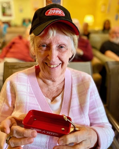 The Inn at Fairview, nursing home in Hudson, NH — Smiling woman holding a red prize wheel toy