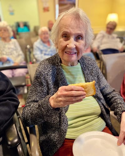 The Inn at Fairview, nursing home in Hudson, NH — Woman holding a sandwich in a social gathering