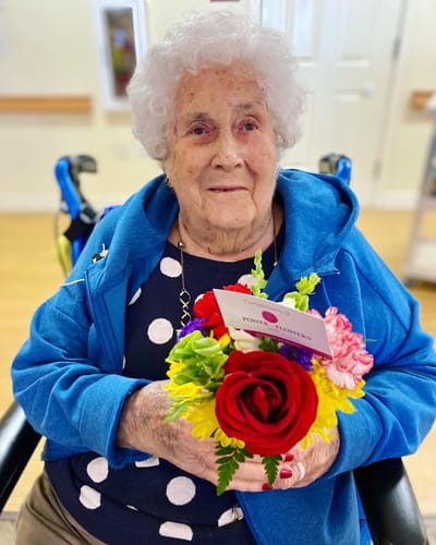 The Inn at Fairview, nursing home in Hudson, NH — Elderly woman holding a bouquet of flowers