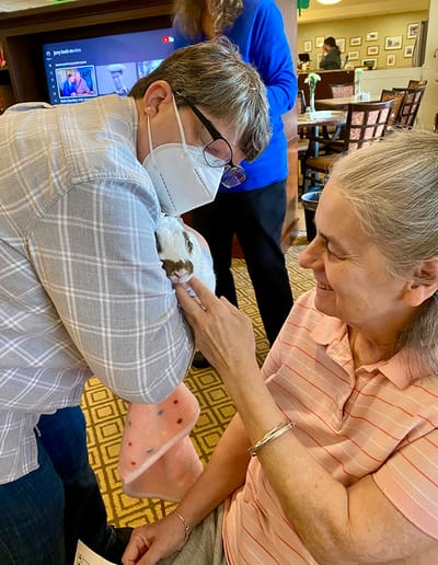 The Inn at Fairview, nursing home in Hudson, NH — Resident interacting with a caregiver and a small pet
