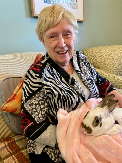 The Inn at Fairview, nursing home in Hudson, NH — Senior resident holding a rabbit in a cozy setting