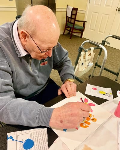 The Inn at Fairview, nursing home in Hudson, NH — Senior resident painting with colorful art supplies