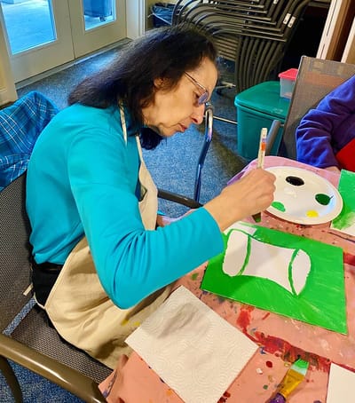The Inn at Fairview, nursing home in Hudson, NH — Senior resident painting at an art activity table