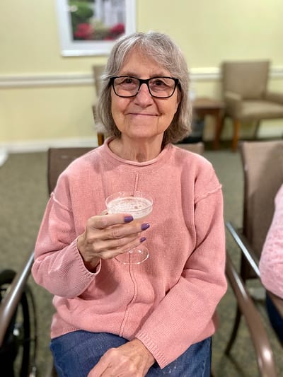 The Inn at Fairview, nursing home in Hudson, NH — Senior resident enjoying a drink in a cozy setting