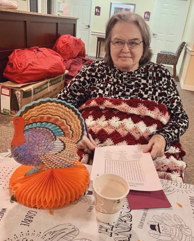 The Inn at Fairview, nursing home in Hudson, NH — Woman sitting with turkey decoration and bingo sheet