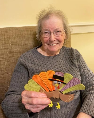 The Inn at Fairview, nursing home in Hudson, NH — Senior resident holding a colorful turkey decoration