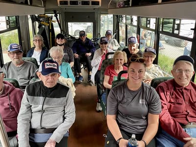 The Inn at Fairview, nursing home in Hudson, NH — Seniors and staff on a bus outing wearing hats