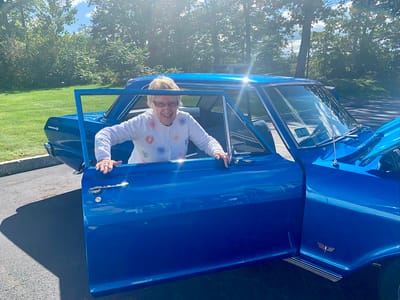 The Inn at Fairview, nursing home in Hudson, NH — Senior woman smiling while entering a classic blue car