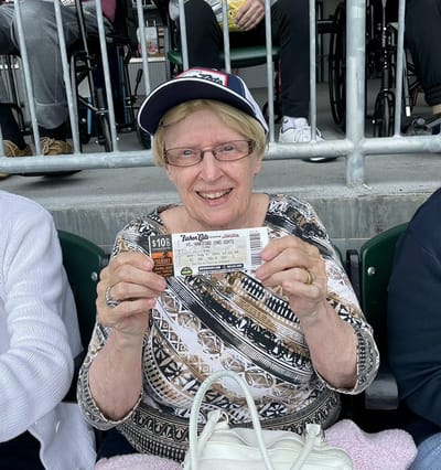 The Inn at Fairview, nursing home in Hudson, NH — Senior woman holding a ticket at a sports event