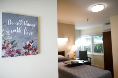 A cozy resident room with a motivational wall art