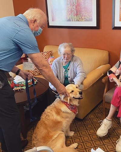 The Inn at Fairview, nursing home in Hudson, NH — Resident interacting with a therapy dog and caregivers