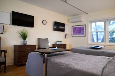 Interior view of a resident room with beds and furnishings