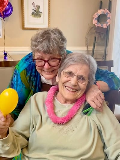 The Inn at Fairview, nursing home in Hudson, NH — Two smiling senior women celebrating together with props