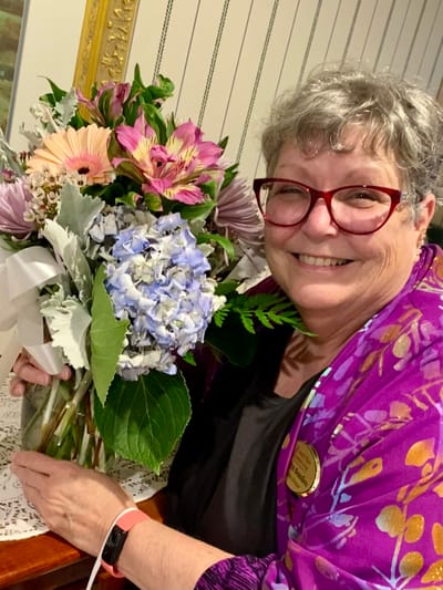 The Inn at Fairview, nursing home in Hudson, NH — Woman holding a large bouquet of flowers