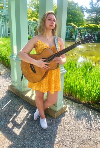 The Inn at Fairview, nursing home in Hudson, NH — Young woman playing guitar in a garden setting