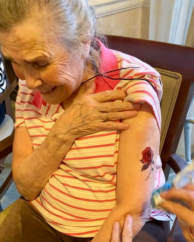 The Inn at Fairview, nursing home in Hudson, NH — Elderly woman smiling with a rose tattoo on her arm