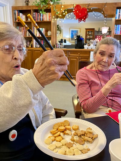 The Inn at Fairview, nursing home in Hudson, NH — Residents enjoying snacks with chopsticks at a dining table