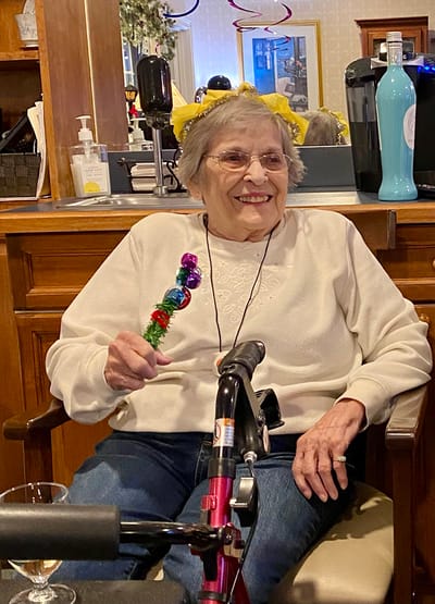 The Inn at Fairview, nursing home in Hudson, NH — Senior resident holding a festive stick in a cheerful setting