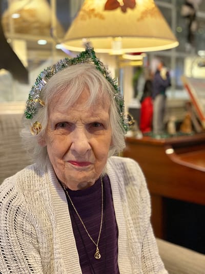 The Inn at Fairview, nursing home in Hudson, NH — Elderly woman with festive headband in cozy setting