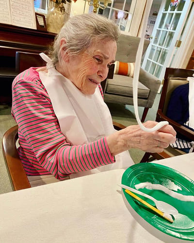 The Inn at Fairview, nursing home in Hudson, NH — Resident enjoying a craft activity with materials on a table