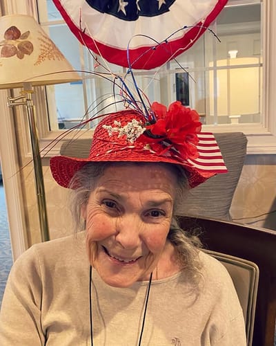 The Inn at Fairview, nursing home in Hudson, NH — Smiling woman wearing a decorative red hat