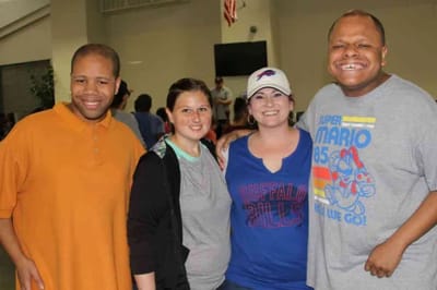 Residents and staff smiling together in an activity space