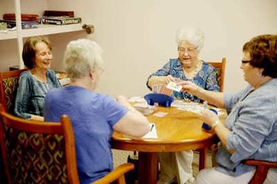 Residents enjoying a card game at a round table