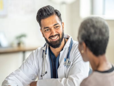A doctor smiling and talking with a senior resident