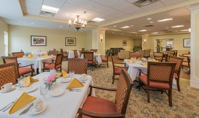 Dining room set up for a meal with flowers on the tables