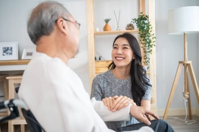 A resident interacting with a staff member in a cozy interior