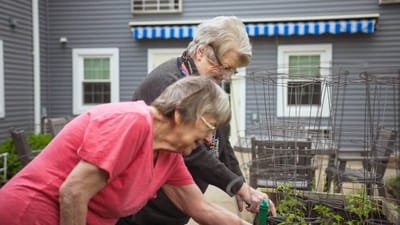 Two residents gardening in the outdoor space