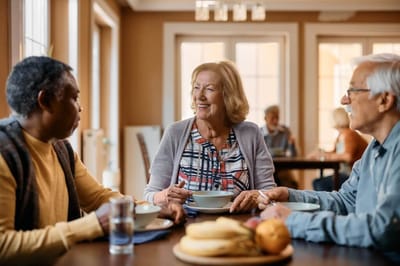 Residents enjoying meals and conversation in a dining room