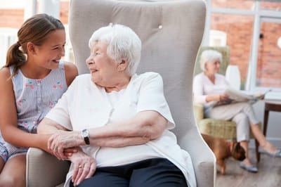 An elderly woman chatting with a young girl in a lounge